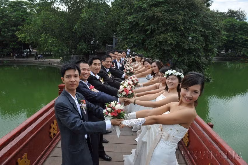Photo d'un mariage de 50 couples venus des trois régions - Nord, Centre et Sud - au lac Hoàn Kiêm (Epée restituée), à Hanoï. Photo : VNA