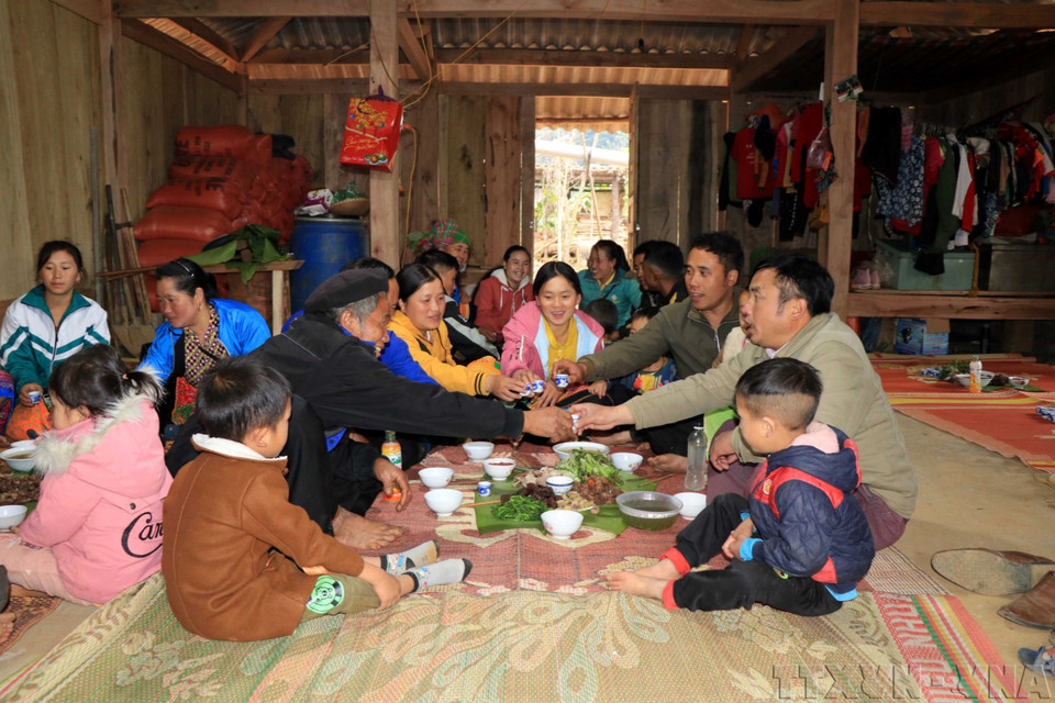 Plusieurs générations d'une famille de l’ethnie H’Mông du district de Bac Yên, province septentrionale de Son La, rassemblées autour d'un repas du Têt. Photo : VNA