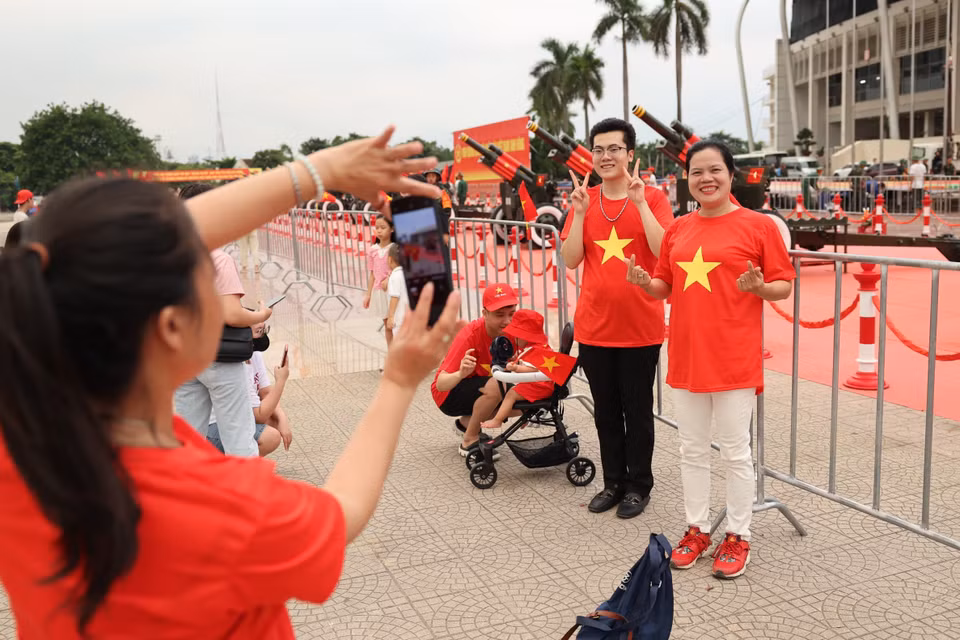 Des habitants enthousiastes prennent des photos souvenirs avec la batterie de canons au stade de My Dinh. Photo : VNA