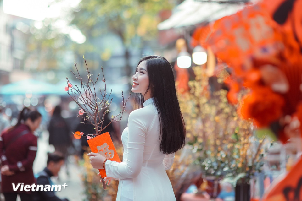 Dans les rues du centre-ville, les Hanoiennes parées de leurs tuniques traditionnelles "ao dai" créent un tableau emblématique du Têt. (Photo : Minh Son/Vietnam+)