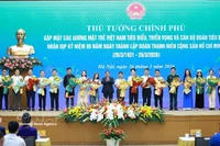 Le Premier ministre Pham Minh Chinh offre des fleurs de félicitations aux jeunes Vietnamiens exemplaires. Photo : VNA