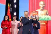 Le secrétaire général du Parti, To Lam, reçoit l’album photo « La gloire appartient à jamais au Peuple », offertpar l’Agence vietnamienne d’Information. Photo: VNA