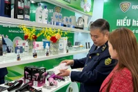 Guider une femme à distinguer des cosmétiques authentiques de produits contrefaits. Photo : Vietnam+