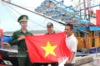 Remise de drapeaux nationaux à des pêcheurs. Photo : VNA