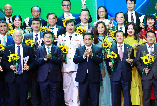 Le Premier ministre Pham Minh Chinh et les représentants des entreprises possédant des produits primés. Photo: VNA thu_tuong.jpg