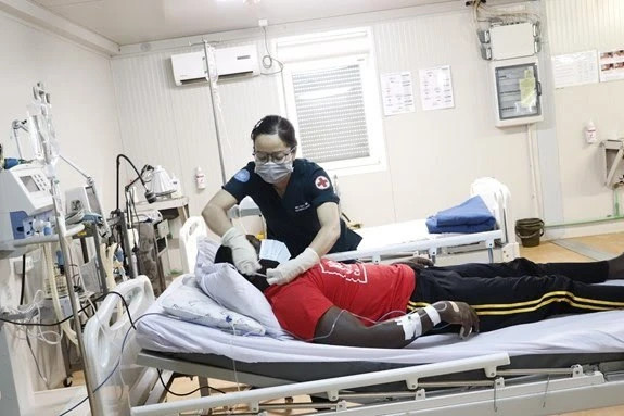Une femme médecin militaire de l'hôpital de campagne n° 3 de niveau 2 au Soudan du Sud examine un patient. Photo : Département des opérations de maintien de la paix Soudan.jpg
