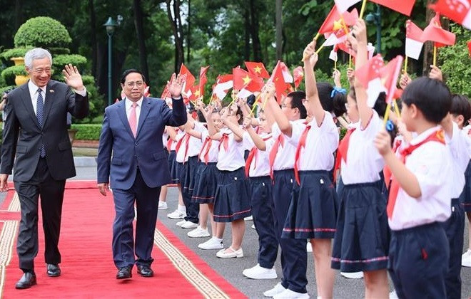 La cérémonie d'accueil du Premier ministre singapourien en visite officielle au Vietnam ảnh 1 La cérémonie d'accueil du Premier ministre singapourien en visite officielle au Vietnam ảnh 1