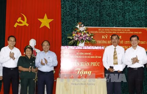 Des dirigeants vietnamiens rendent visite aux personnes méritantes ảnh 1