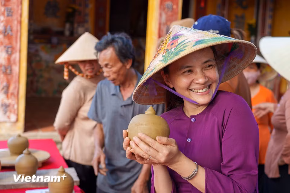 Le sourire radieux d'une artisane de Thanh Ha après avoir achevé une pièce de poterie fraîchement façonnée. Photo : VNA
