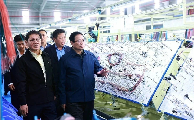 Le Premier ministre Pham Minh Chinh visite une chaîne de production d'une entreprise à Quang Nam. Photo: VNA