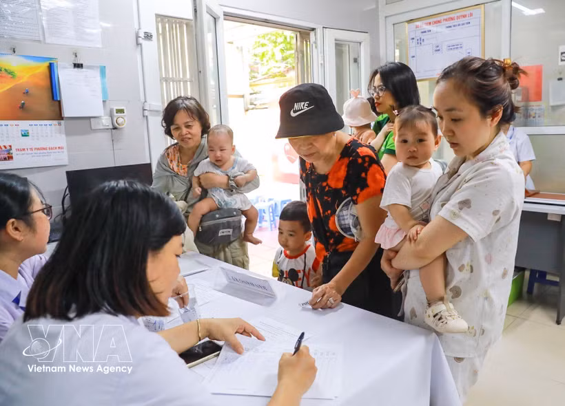 Des familles amènent leurs enfants pour recevoir de la vitamine A au poste de santé du quartier de Bach Mai, à Hanoi. Photo: VNA
