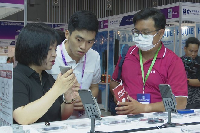 Des visiteurs s'intéressent aux produits de haute technologie. Photo: VietnamPlus