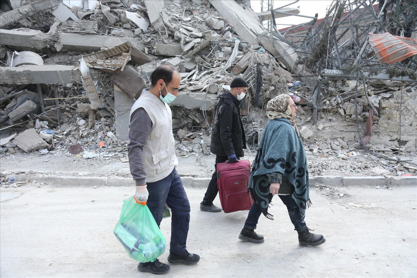 Des personnes marchent à travers les décombres après des attaques. Photo: Xinhua/VNA