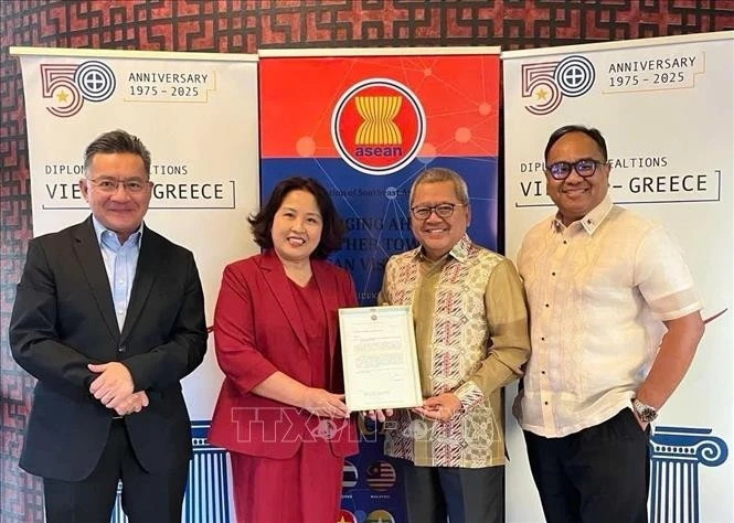 L’ambassadrice Pham Thi Thu Huong (veste rouge) transmet la présidence tournante de l’ACAT à l’ambassadeur d’Indonésie en Grèce. Photo: VNA