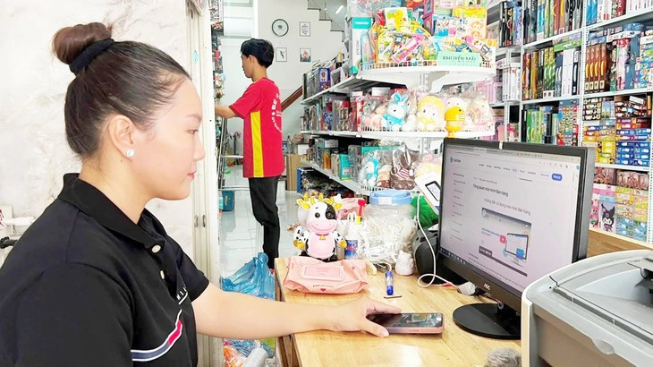 Une petite commerçante applique des factures électroniques générées par des caisses enregistreuses. Photo: tuoitre.vn