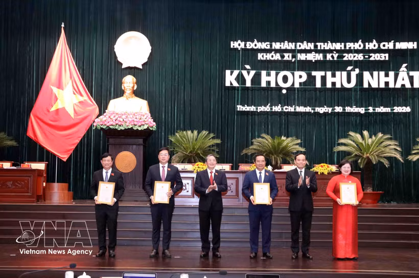 Trân Luu Quang (2e à partir de la droite), membre du Bureau politique et secrétaire du Comité du Parti de Hô Chi Minh-Ville, et Nguyên Duc Hai (3e à partir de la gauche), vice-président de l'Assemblée nationale, remettent les décisions de reconnaissance aux membres du Conseil populaire municipal. Photo: VNA