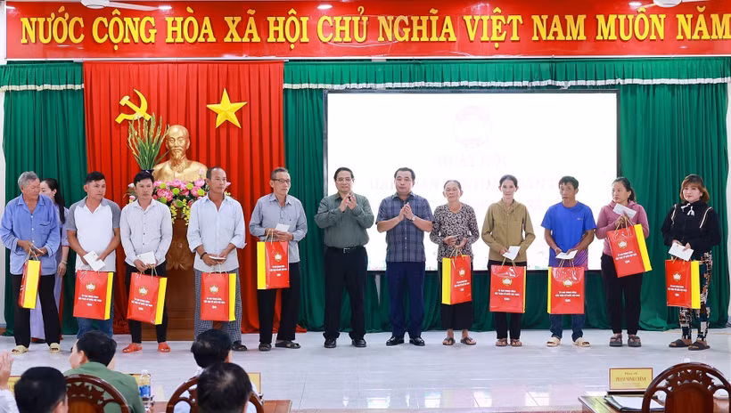 Le Premier ministre Pham Minh Chinh remet des cadeaux à des familles bénéficiaires de politiques sociales. Photo: VNA