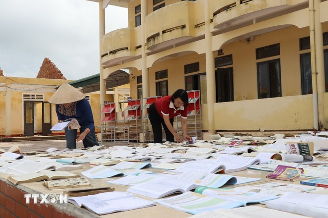Les enseignants de Hà Tinh profitent du soleil pour sécher les livres des élèves. Photo : VNA thu-tuong-1.jpg