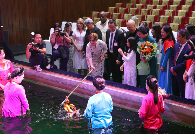 Au Théâtre des marionnettes sur l’eau de Thang Long, la première dame cubaine et sa délégation ont découvert un art séculaire issu de la civilisation rizicole vietnamienne. Photo : VNA vna-potal-phu-nhan-ngo-phuong-ly-va-phu-nhan-lis-cuesta-peraza-thuong-thuc-mua-roi-nuoc-tham-quan-den-ngoc-son-8248714.jpg