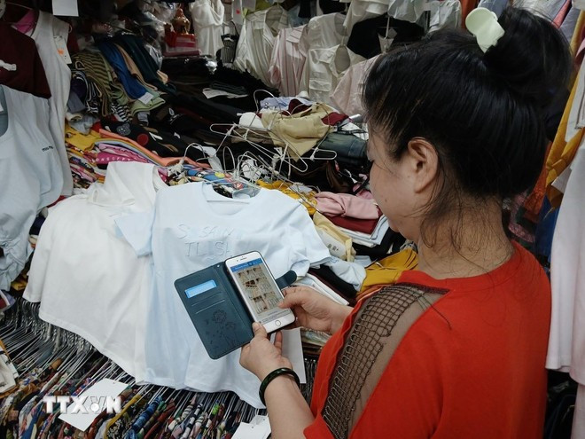 Avec un simple smartphone et une connexion internet, les commerçants peuvent désormais vendre, encaisser et trouver de nouveaux clients en ligne. Photo : VNA chuyen-doi-so-tai-cac-cho-truyen-thong-o-da-nang-1208-2.jpg