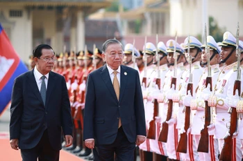 Le secrétaire général du PCV To Lam (droite) et Samdech Techo Hun Sen passent en revue la garde d'honneur de l'Armée royale cambodgienne. Photo : VNA