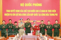 Des délégués à la cérémonie de remise de la décision de nomination au lieutenant-colonel Nguyen Hoang Long (quatrième, droite). Photo : VNA
