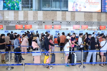 Des passagers effectuent les formalités d'enregistrement au terminal domestique T1 de l'aéroport international de Noi Bai. Photo: VNA