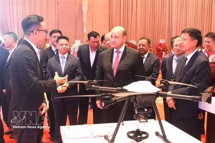 Le vice-Premier ministre et ministre cambodgien de la Fonction publique, Hun Many, (au centre), assiste à une présentation sur le drone cargo de Metfone Express. Photo : VNA