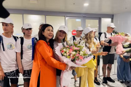 La directrice du Département du tourisme de Hanoï, Dang Huong Giang, offre des fleurs pour féliciter le 5 millionième visiteur international et une délégation espagnole à l'aéroport de Noi Bai, le 7 juillet 2026 après-midi. Photo : VNA