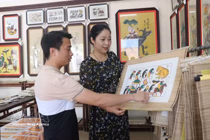 Des visiteurs admirent les estampes de Dong Ho. Photo: VNA