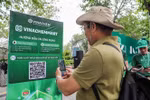 Les gens scannent directement le code QR de la plateforme de commerce électronique VinachemMart dans la rue piétonne du lac Hoàn Kiêm. Photo: VNA