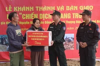 Le général de division Pham Hong Phuc (à droite), du commandement de la police mobile, félicite la famille de Nguyen Dinh, commune de Thuong Duc, pour leur nouvelle maison. Photo : VNA