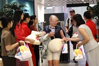 Offre des cadeaux aux passagers venus de Manille (Philippines) et de Bali (Indonésie). Photo: VNA