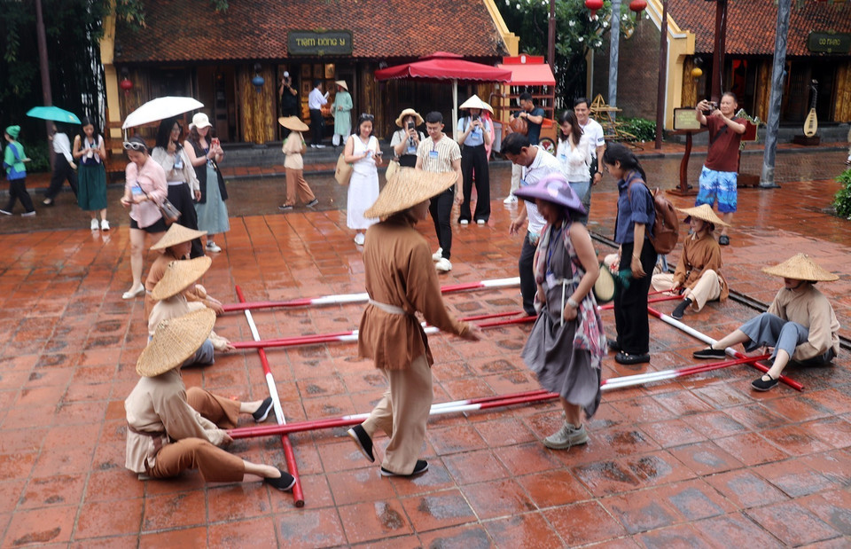 Des touristes participent à une danse du bambou. Photo : Le Huy Hai - VNA