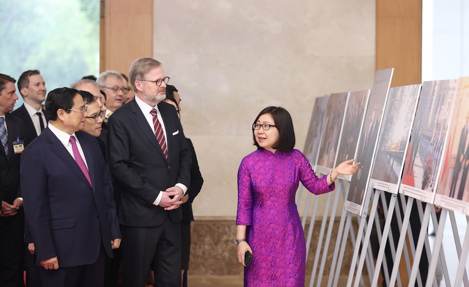 La directrice générale adjointe de l'Agence vietnamienne d'information, Doan Thi Tuyet Nhung, présente une exposition de photos sur les relations d'amitié entre le Vietnam et la République tchèque aux deux Premiers ministres (Hanoï, 21 avril 2023). Photo : Duong Giang/VNA