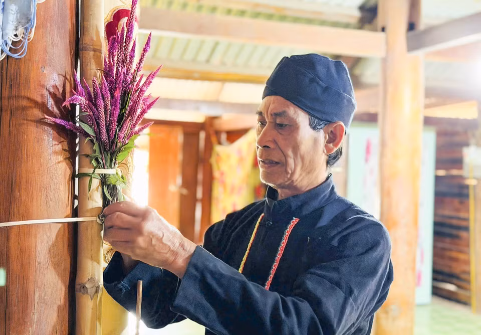 Le chaman attache les fleurs de crête de coq dans sa maison pour accomplir le rituel du Nouvel An.