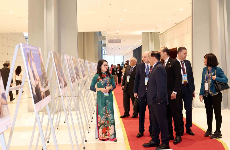 Des délégués internationaux visite l'exposition de photos de l'Agence vietnamienne d'Information lors de la cérémonie d'ouverture à la signature de la Convention de Hanoï le 25 octobre. Photo: VNA
