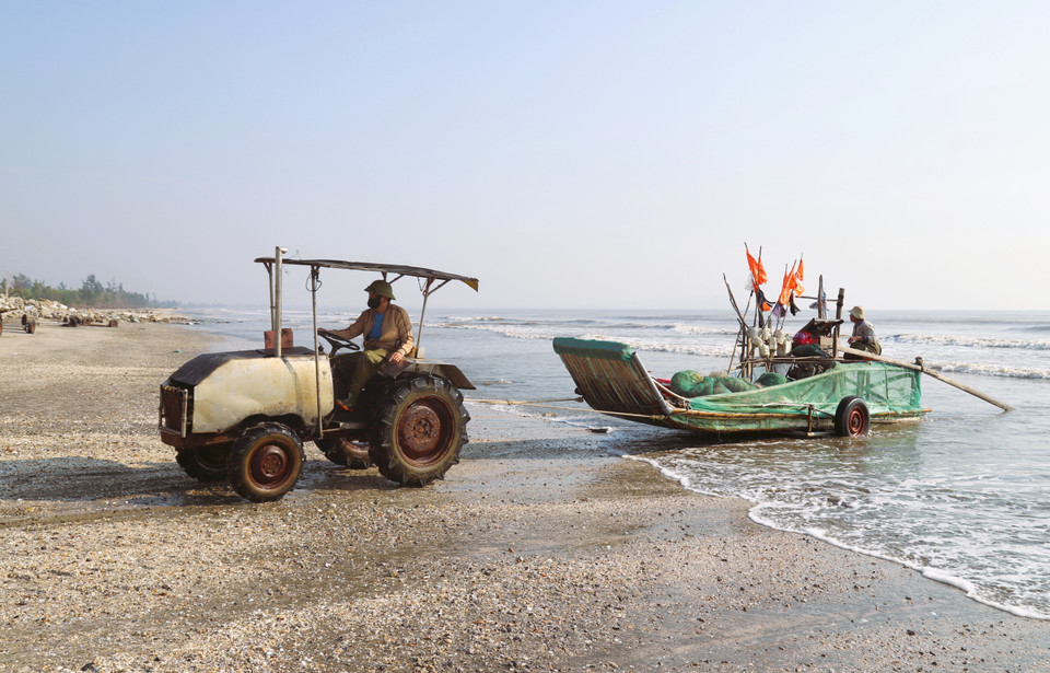 Le radeau de pêche aux crabes vient d’accoster et est hissé sur la plage à l’aide d’un tracteur.