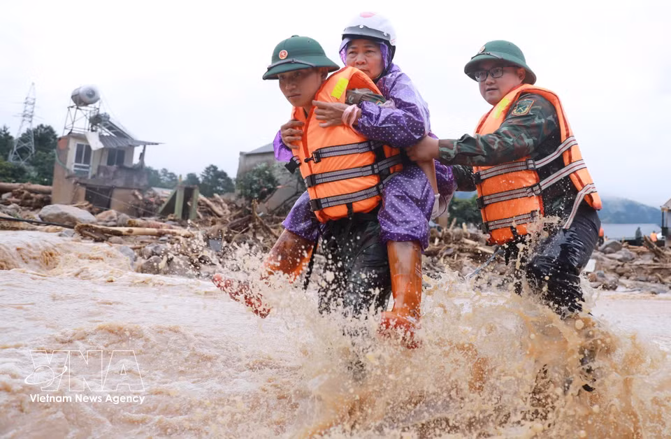 Les forces de la police et de l'armée évacuent des habitants de la zone touchée par les crues éclair dans la commune de Muong Than, province de Lai Chau. Photo : VNA