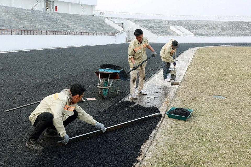 Le revêtement final est en train d'être appliqué sur les derniers tronçons de la piste. Photo: VNA