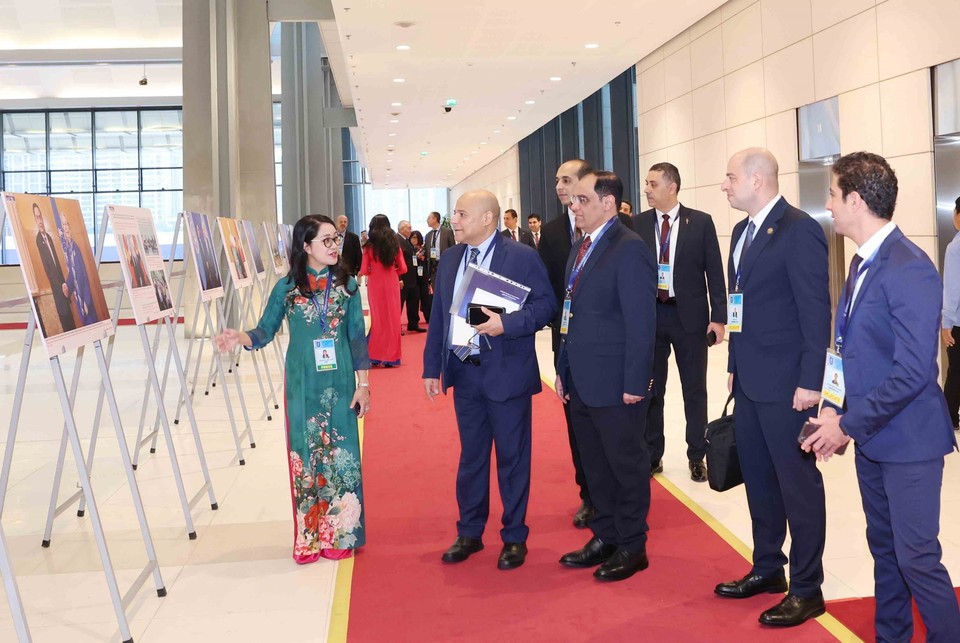Des délégués internationaux visite l'exposition de photos de l'Agence vietnamienne d'Information lors de la cérémonie d'ouverture à la signature de la Convention de Hanoï le 25 octobre. Photo: VNA