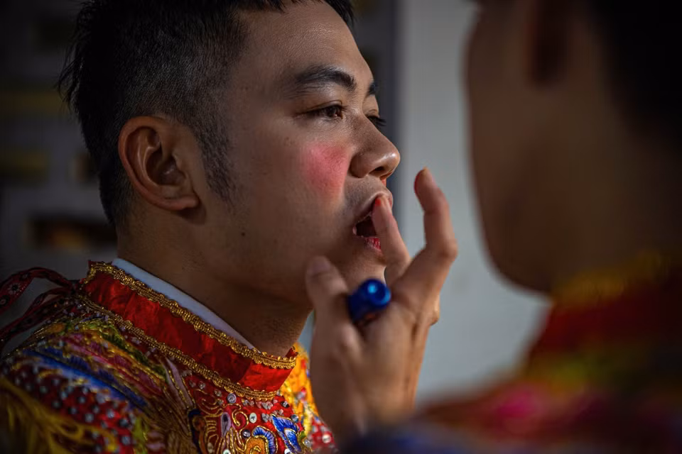 Un membre du club de tambours Trieu Khuc se maquille.