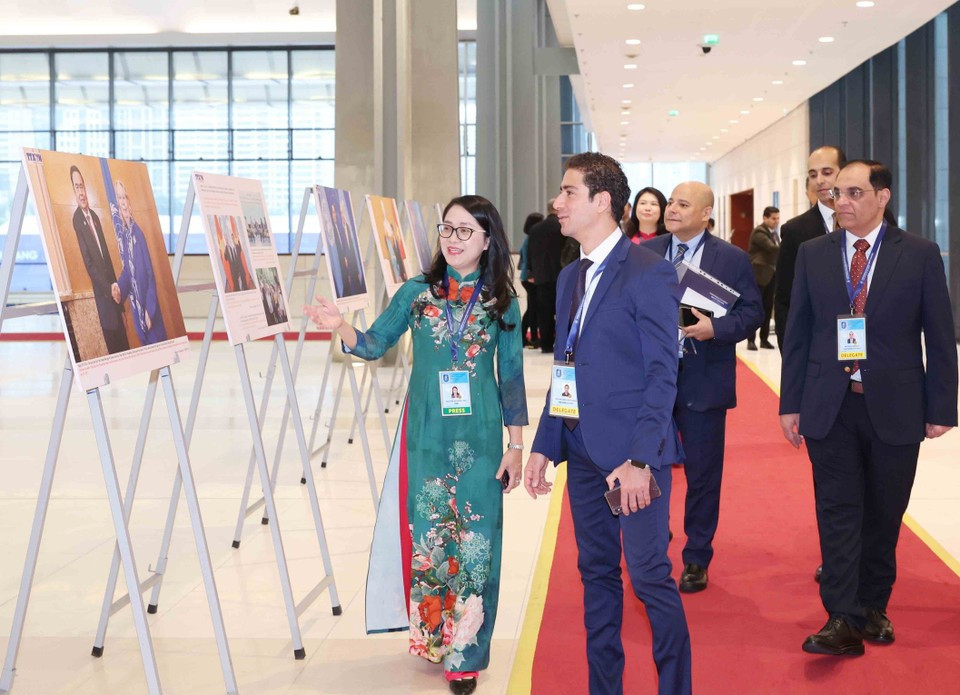 Des délégués internationaux visite l'exposition de photos de l'Agence vietnamienne d'Information lors de la cérémonie d'ouverture à la signature de la Convention de Hanoï le 25 octobre. Photo: VNA