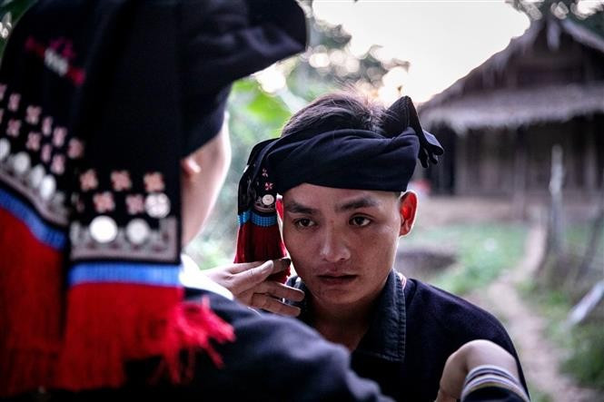 Le marié, vêtu du costume traditionnel, présente du vin, accomplit le rituel de demande en mariage et salue les frères, sœurs et beaux-frères de la mariée. Photo: Trong Dat/VNA