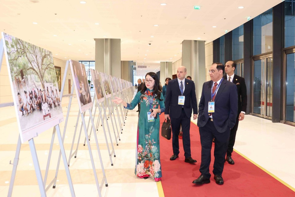 Des délégués internationaux visite l'exposition de photos de l'Agence vietnamienne d'Information lors de la cérémonie d'ouverture à la signature de la Convention de Hanoï le 25 octobre. Photo: VNA
