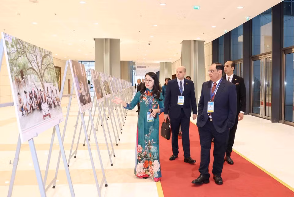 Des délégués internationaux visite l'exposition de photos de l'Agence vietnamienne d'Information lors de la cérémonie d'ouverture à la signature de la Convention de Hanoï le 25 octobre. Photo: VNA