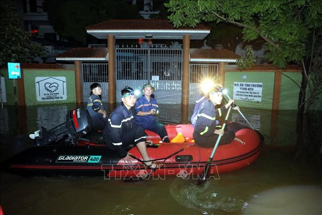 Des policiers et des soldats de la province de Lang Son viennent en aide aux habitants des zones inondées de la commune de That Khe, dans la province de Lang Son, la nuit. Photo : Van Dat - VNA