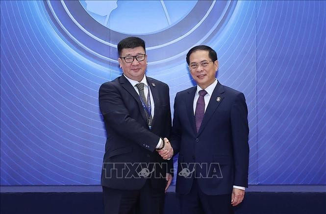 Le vice-Premier ministre Bùi Thanh Son accueille les chefs de délégation participant à la cérémonie d'ouverture à la signature de la Convention de Hanoï, le matin du 25 octobre. Photo : Pham Kien - VNA