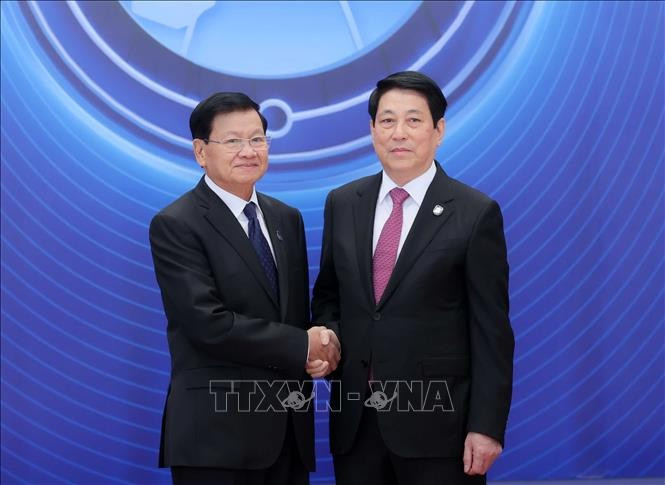 Le président Luong Cuong (droite) accueille le secrétaire général du PPRL et président lao Thongloun Sisoulith à la cérémonie d'ouverture à la signature de la Convention de Hanoï. Photo : VNA