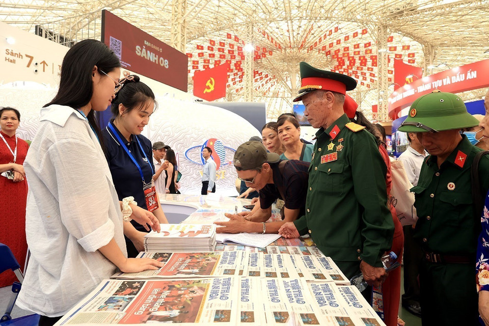 Le public reçoit gratuitement des journaux au stand de l’Agence Vietnamienne d’Information.